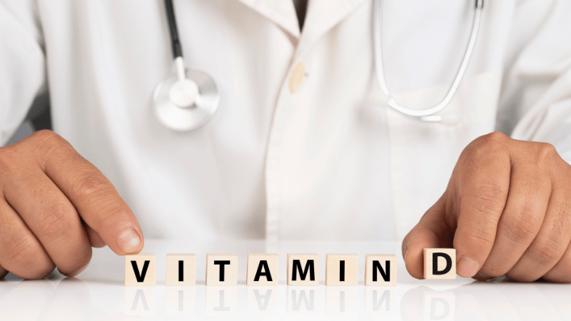 Arzt mit Würfeln mit den Buchstaben Vitamin D